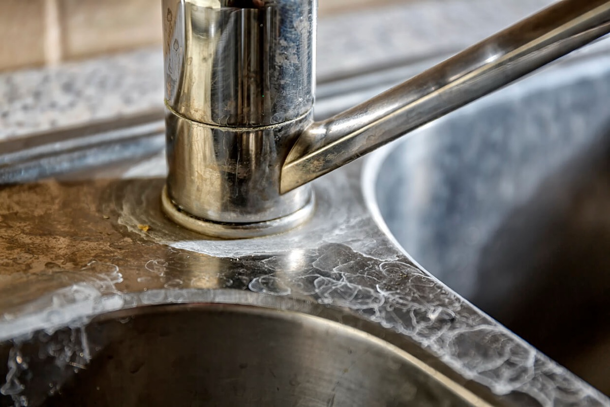Hard water scale and mineral deposits on a faucet - causes, costs, and solutions
